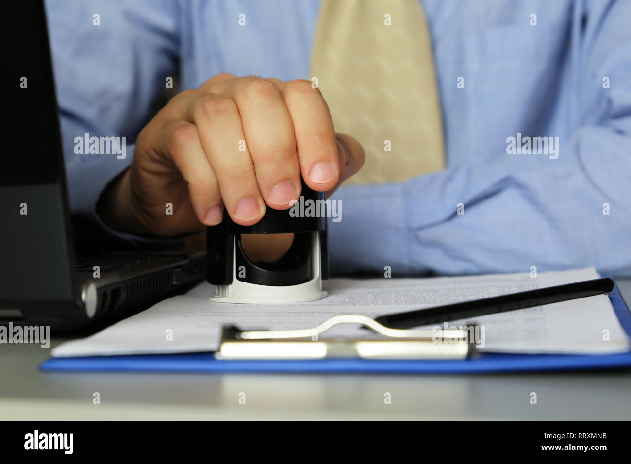 L'homme en vêtements d'affaires met un cachet sur les documents de l'office. Concept de l'autorisation officielle, gestionnaire, affaires, contrat, Banque D'Images