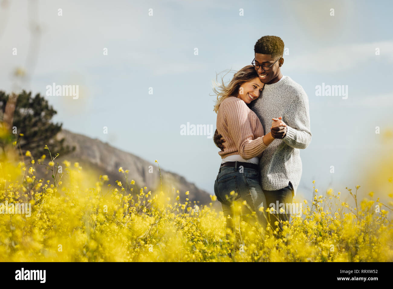 Heureux couple dansant ensemble à l'extérieur. African man and Caucasian woman enjoying a le temps de qualité ensemble. Banque D'Images