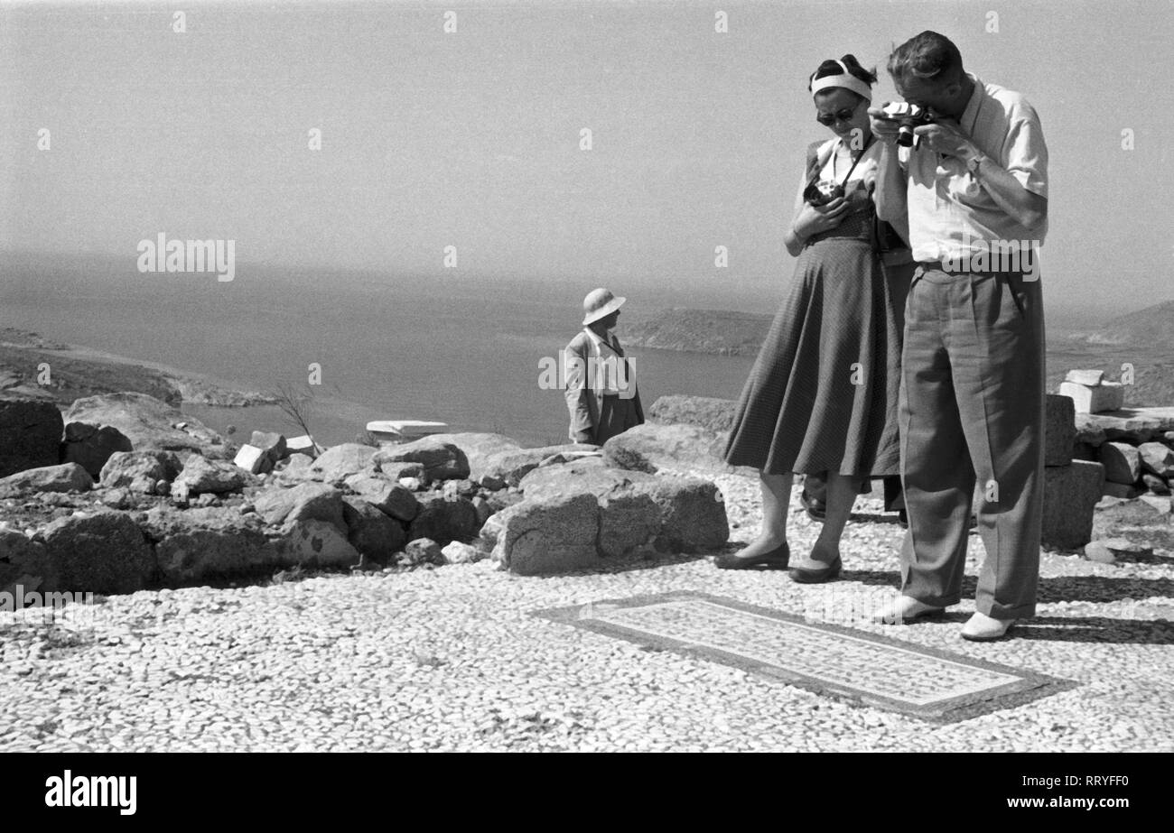 France, Grèce - Touristen fotografieren Mosaik eine der Tempelanlage Indictment Statement of Individual Responsibility am Boden von auf Ialyssos Rhodes, Greece, 1950er Jahre. Les touristes de prendre des photos d'une mosaïque d'inscription sur le sol de la demeure du temple d''Ialyssos sur Rhodes, Grèce, 1950. Banque D'Images