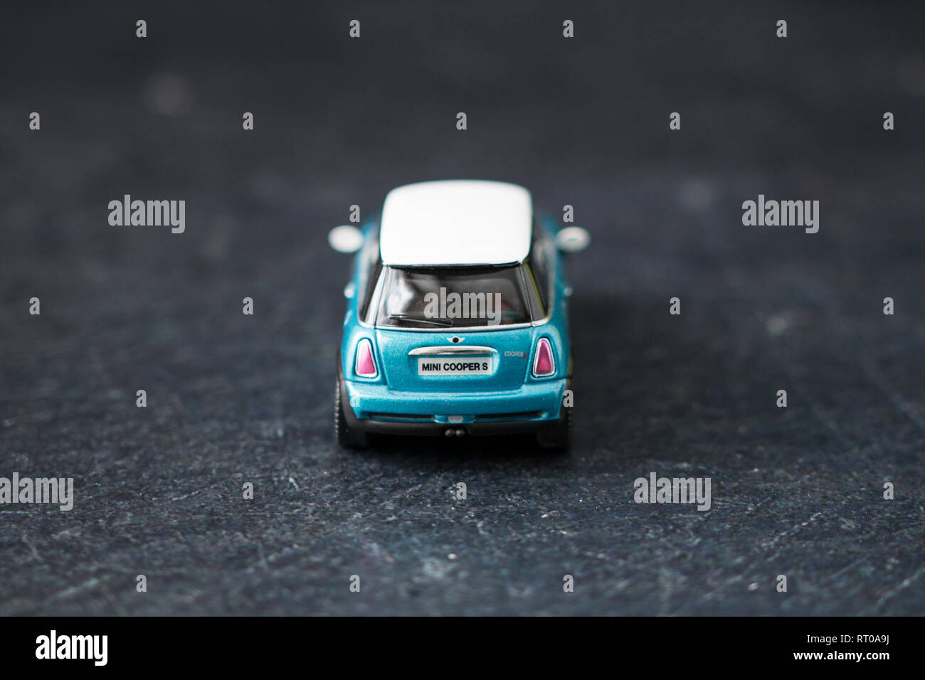 Une voiture miniature bleu sarcelle Mini Cooper S en métal dans des photographies macro sur fond d'ardoise. Banque D'Images