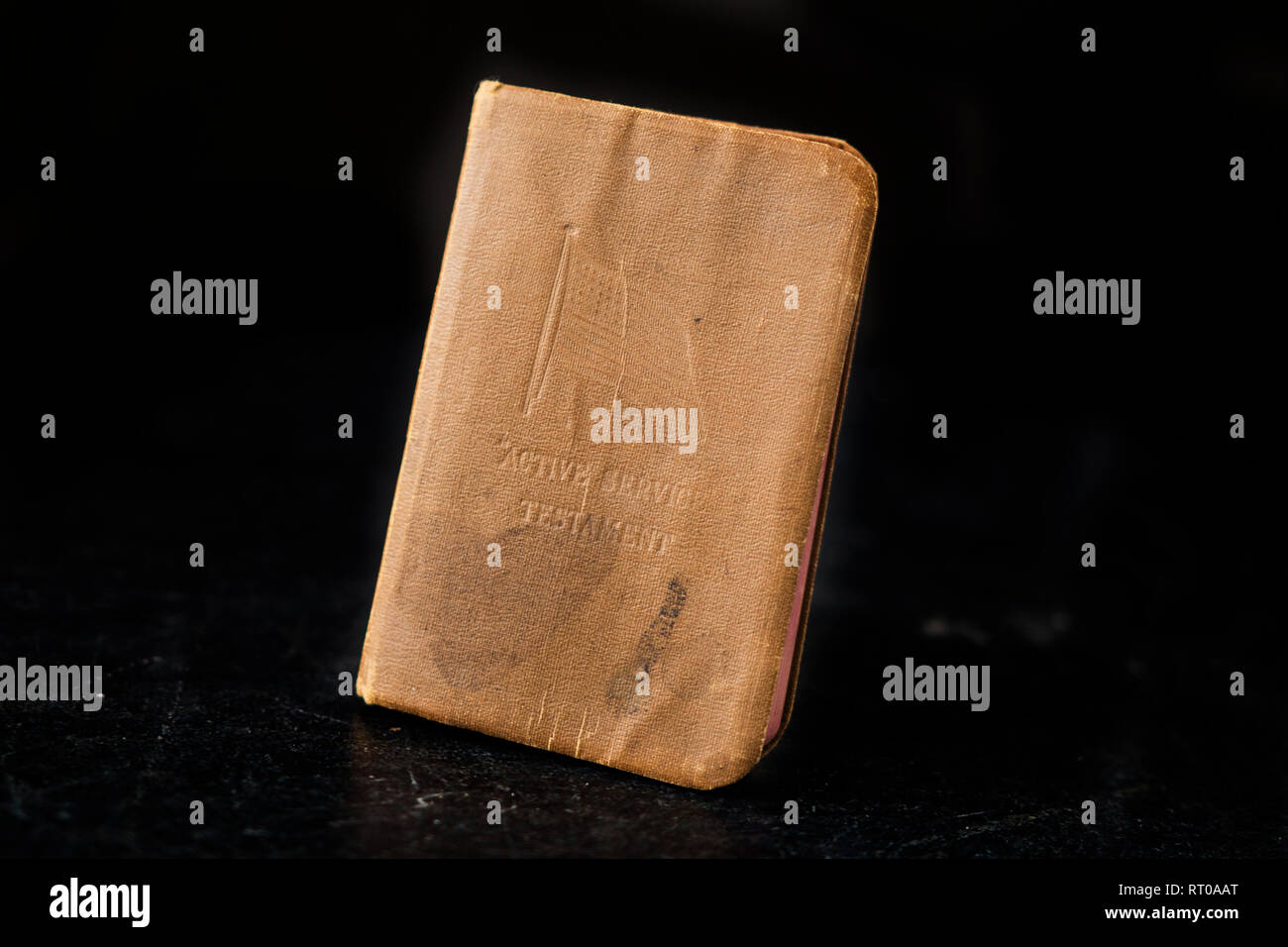 Un testament de service actif, ou la Bible d'un petit soldat de la première Guerre mondiale, voulait tenir dans une poche, sur un fond de marbre noir. Banque D'Images