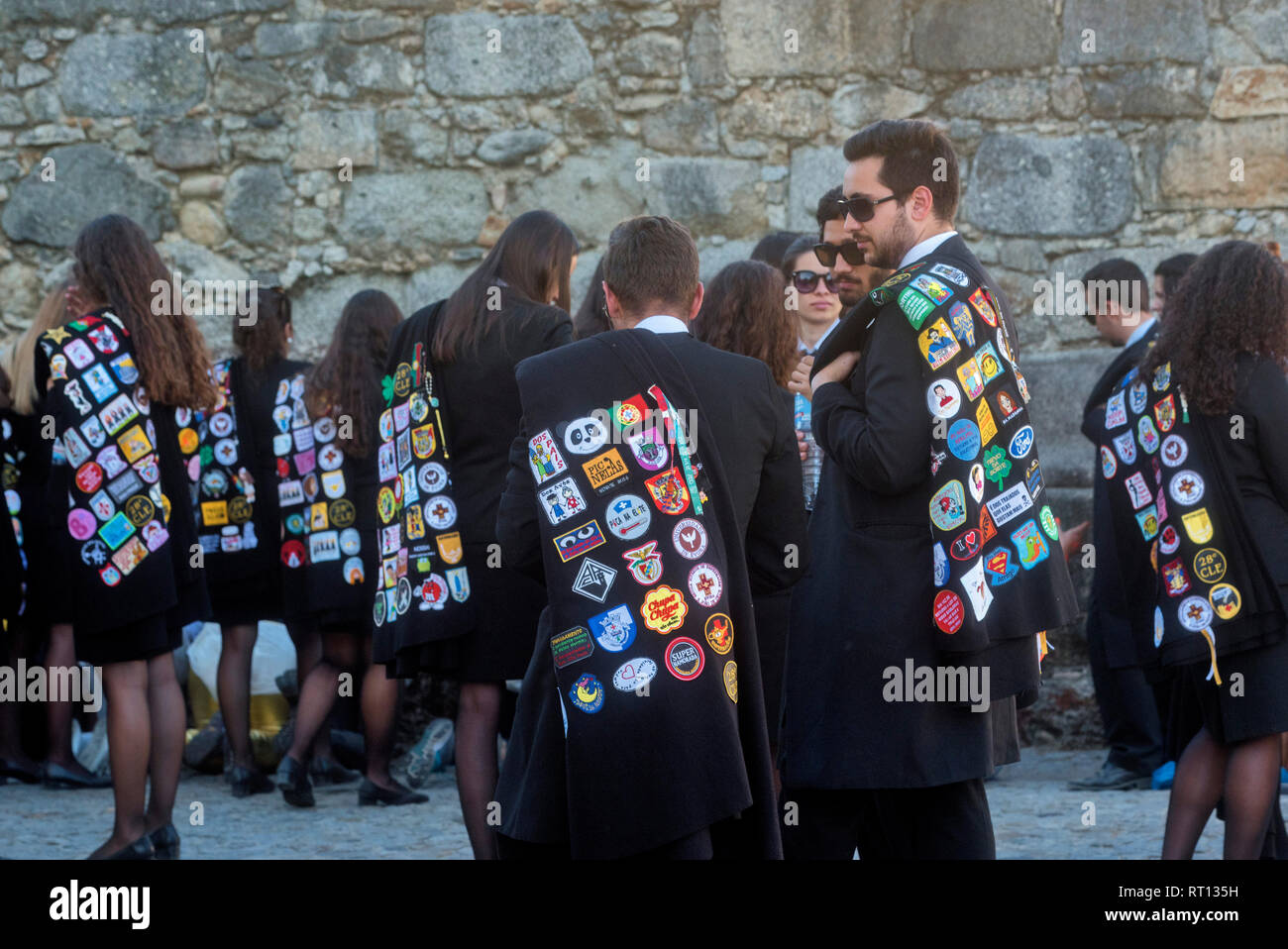 Costume d'étudiant avec cape noire couverte d'écusson des collèges à Evora (Alentejo, Portugal Banque D'Images