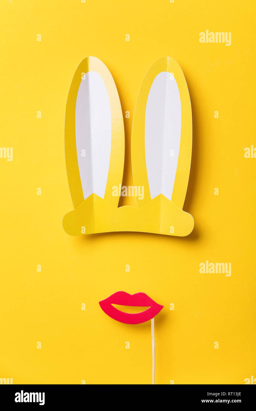 Les oreilles de lapin de Pâques et lèvres rouge sur jaune. Design plat minimal Banque D'Images