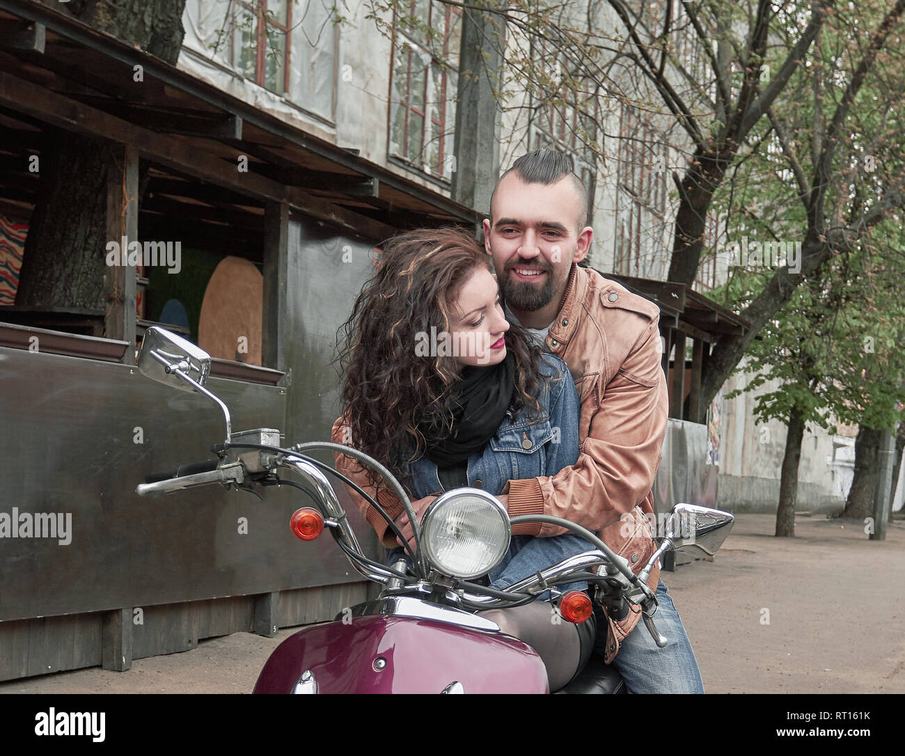 Couple in love équitation une moto sur une rue de la ville. Banque D'Images