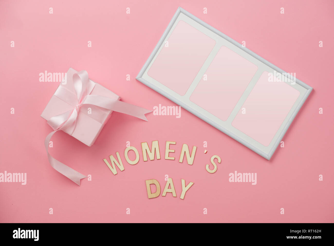 La journée de la femme, concept heureux jour de la femme, Journée internationale de la femme. Texte jour Womans, en bois avec cadre cadeau rose sur fond de corail Banque D'Images