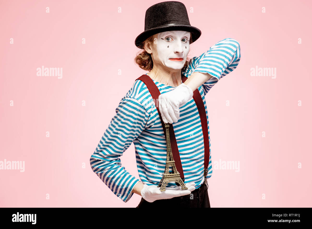 Maquillage du visage blanc avec Pantomime posant avec Tour Eiffel sur le fond rose. Concept mime français Banque D'Images