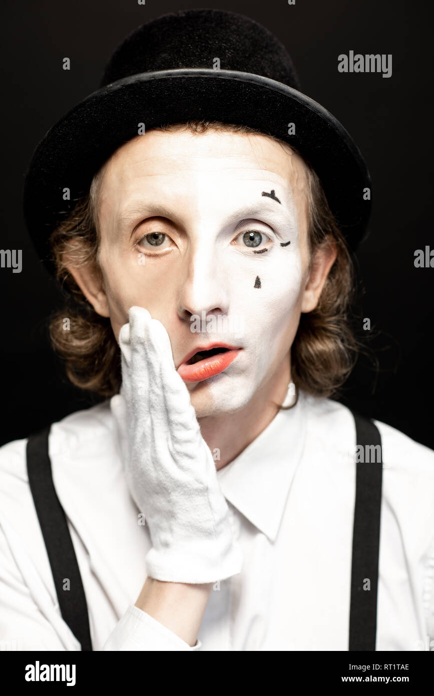 Portrait d'une pantomime avec un make-up d'un côté de son visage sur le fond noir. Concept d'une scission de la personnalité Banque D'Images