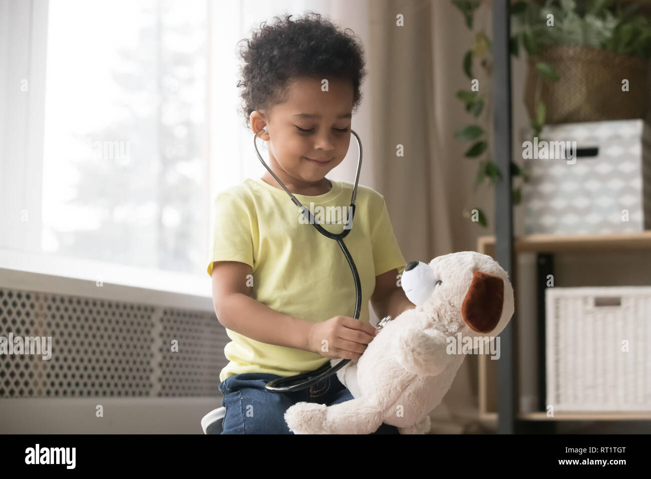 Cute african boy playing with toy comme doctor holding stethoscope Banque D'Images