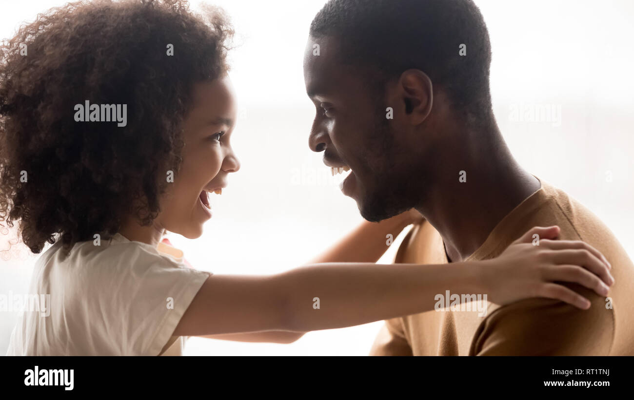 Famille heureuse race mixte enfant cute girl embracing black père riant Banque D'Images