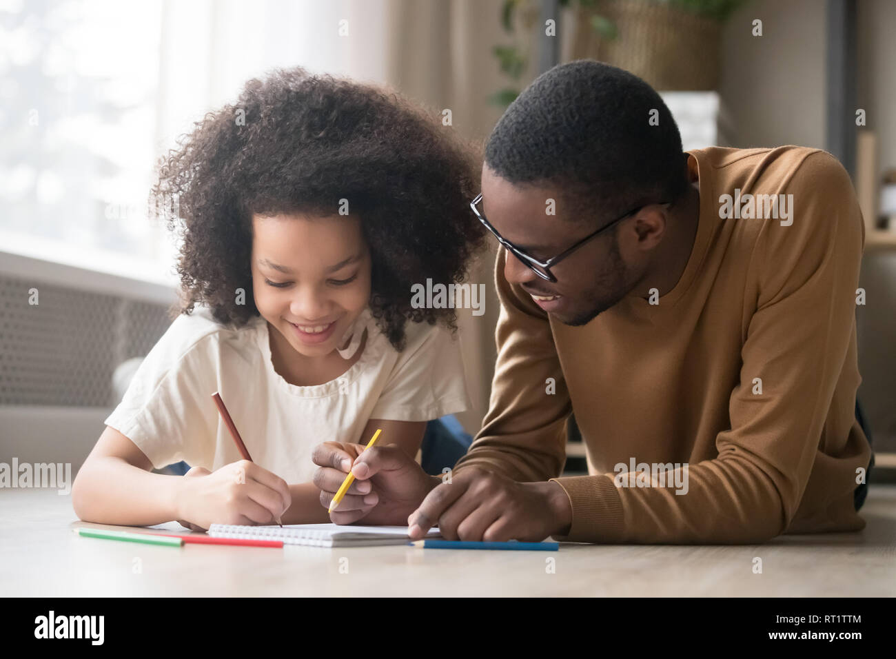 Papa noir soins dessin avec crayons de couleur fille enfant enseignement Banque D'Images