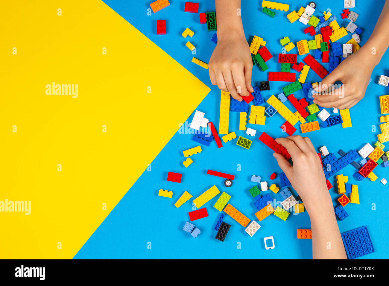 Les mains des enfants jouer avec des blocs lego colorés sur la table Banque D'Images