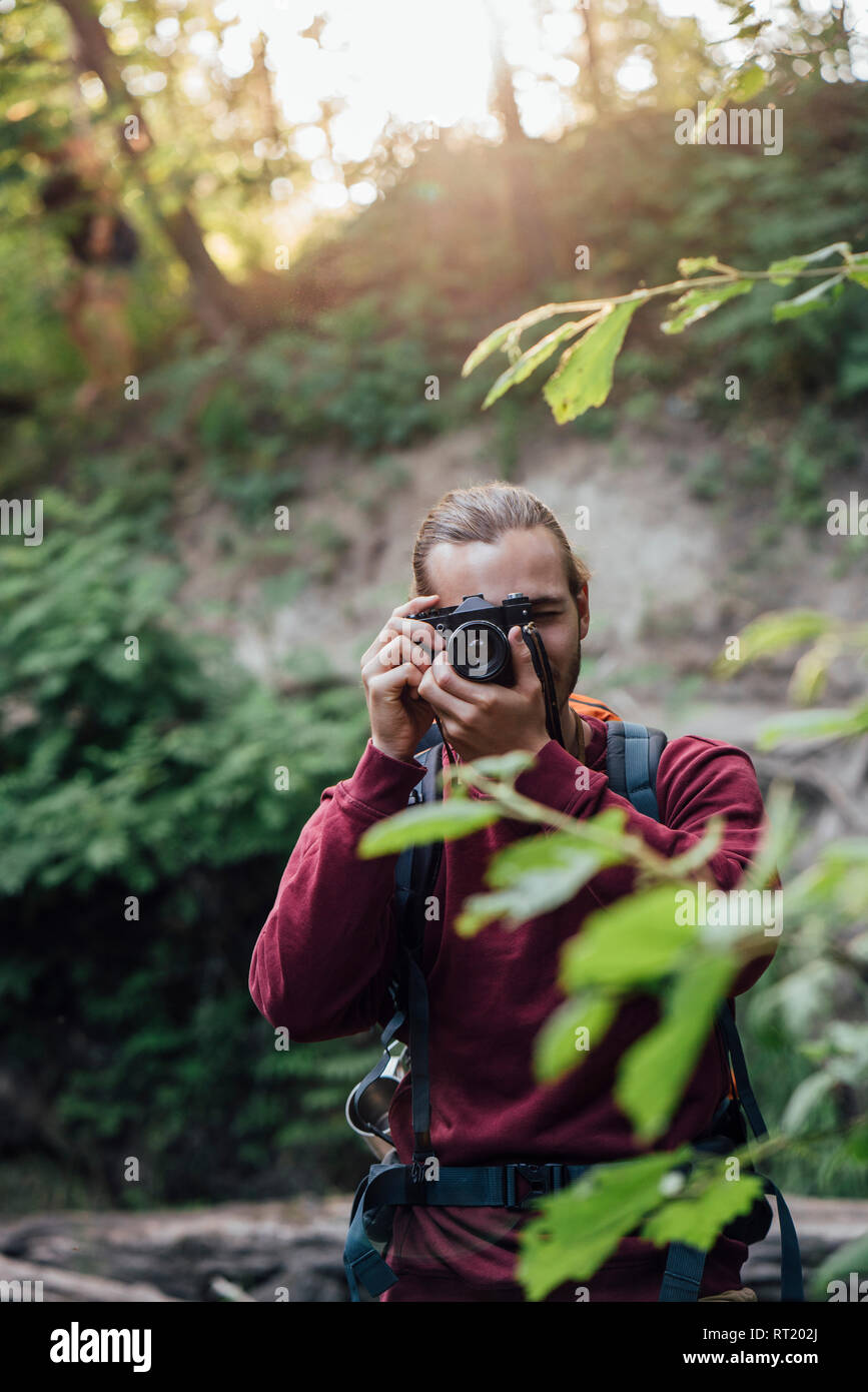 Jeune randonneur prenant photo dans une forêt Banque D'Images