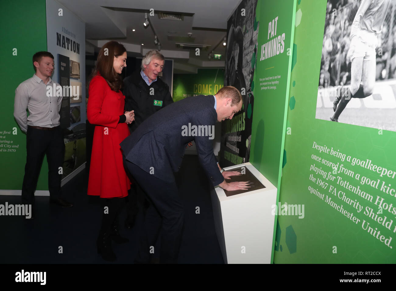 Le duc de Cambridge place ses mains dans la troupe de Pat Jennings, regardé par l'ancien gardien de but (centre), la duchesse de Cambridge et de l'éducation et du patrimoine manager Steven Garret, lors de leur visite à Windsor Park, Belfast dans le cadre de leur visite de deux jours à l'Irlande du Nord. Banque D'Images