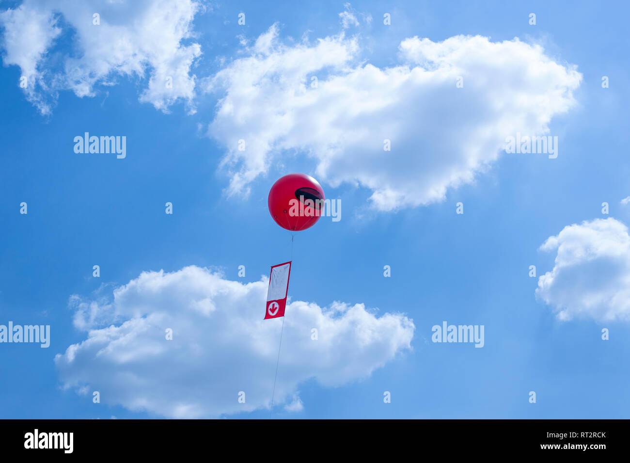Ballon publicitaire rouge dans le ciel bleu Banque D'Images