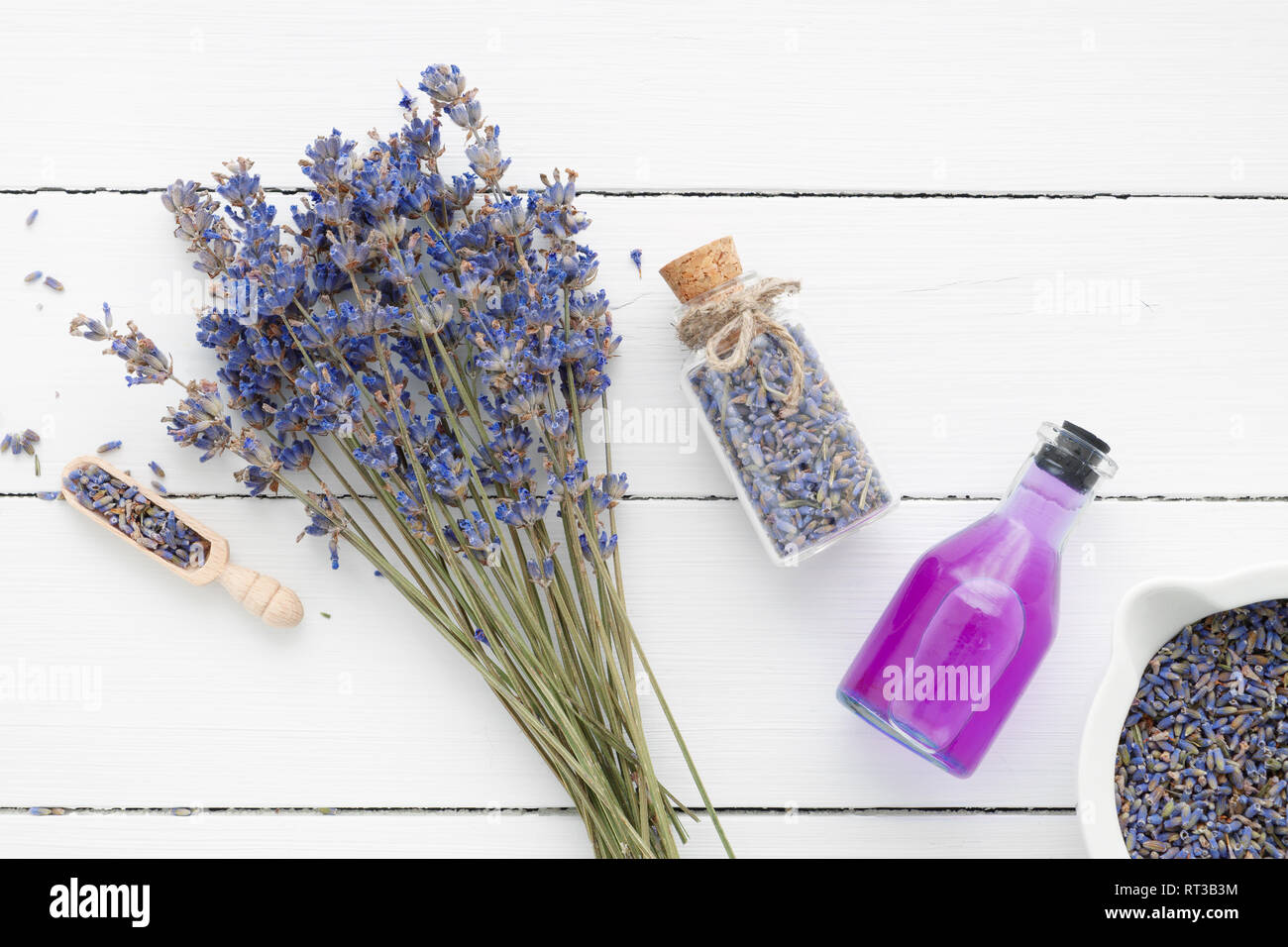 Bouteille d'huile essentielle ou de verre, mortier, fleurs de lavande sur fond blanc. Vue d'en haut. Mise à plat. Banque D'Images