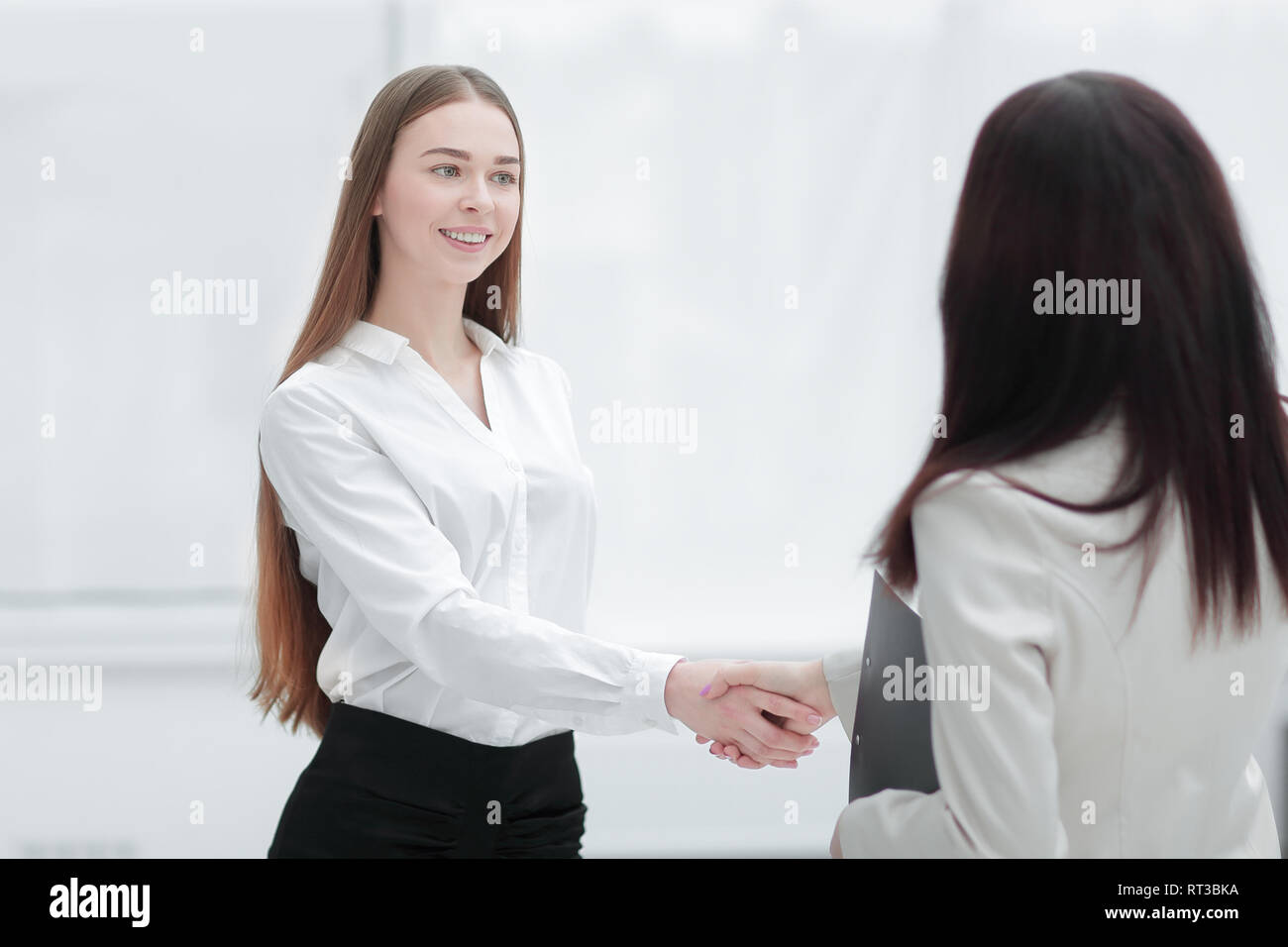 Successful business woman shaking hands with employé Banque D'Images