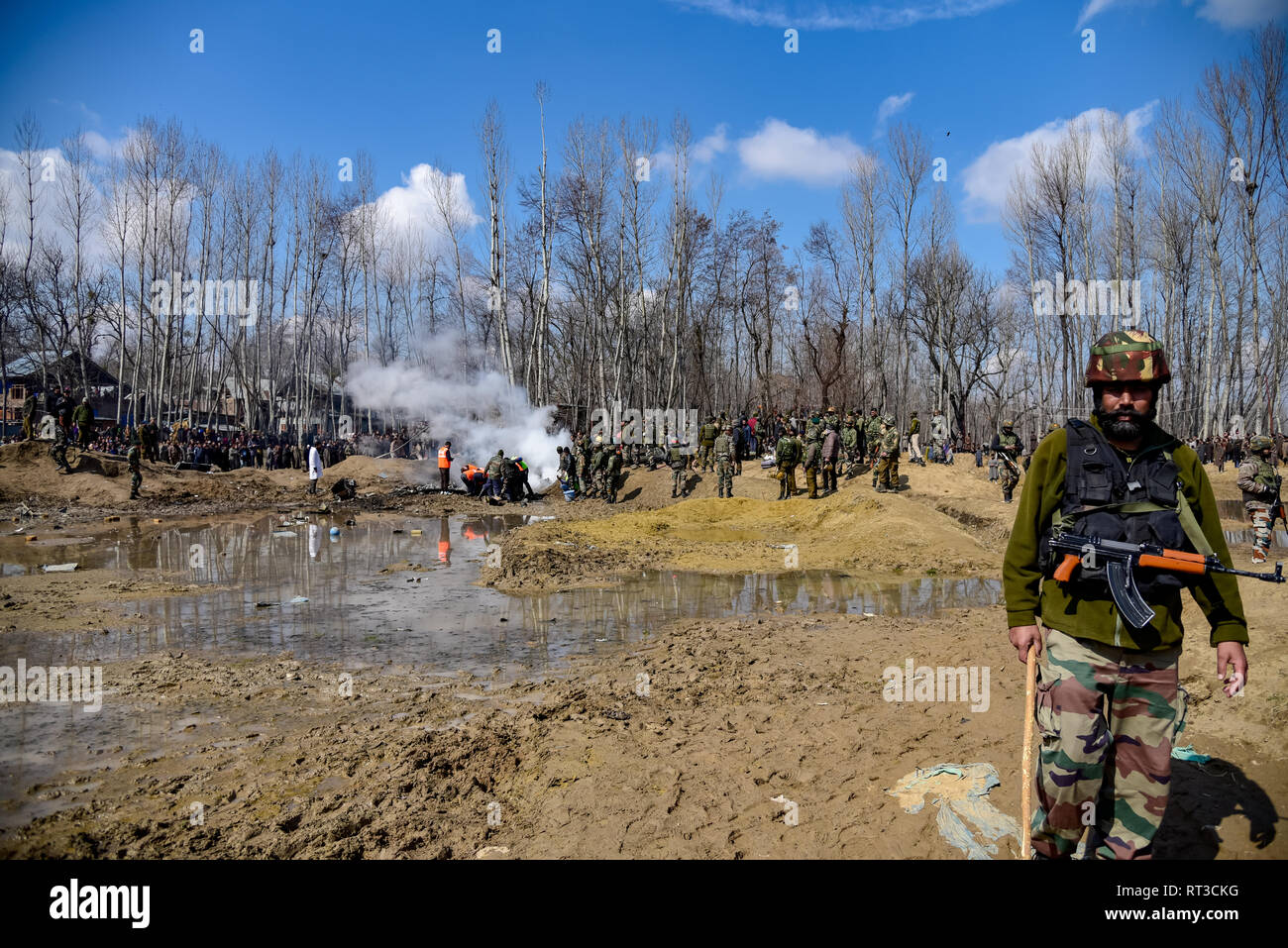 Les hommes de l'armée indienne sont vus debout près de l'épave d'un avion indien qui s'est écrasé dans la région de Budgam. Un civil et six membres des forces aériennes indiennes ont été tués après un broyeur Mi-17 s'est écrasé près de village de Budgam Garend Kalan qui est à 30 km de Srinagar, capitale d'été du Cachemire. Banque D'Images