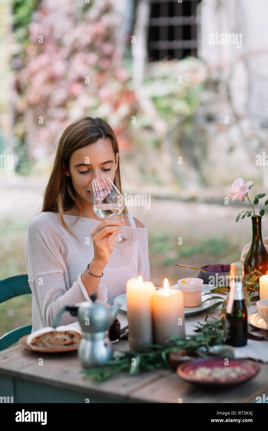 Dégustation femme verre de vin à table de jardin Banque D'Images