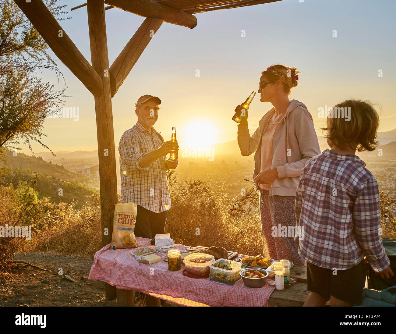 Le Chili, Santiago, la mère avec son grand-père et fils un pique-nique dans les montagnes au coucher du soleil Banque D'Images