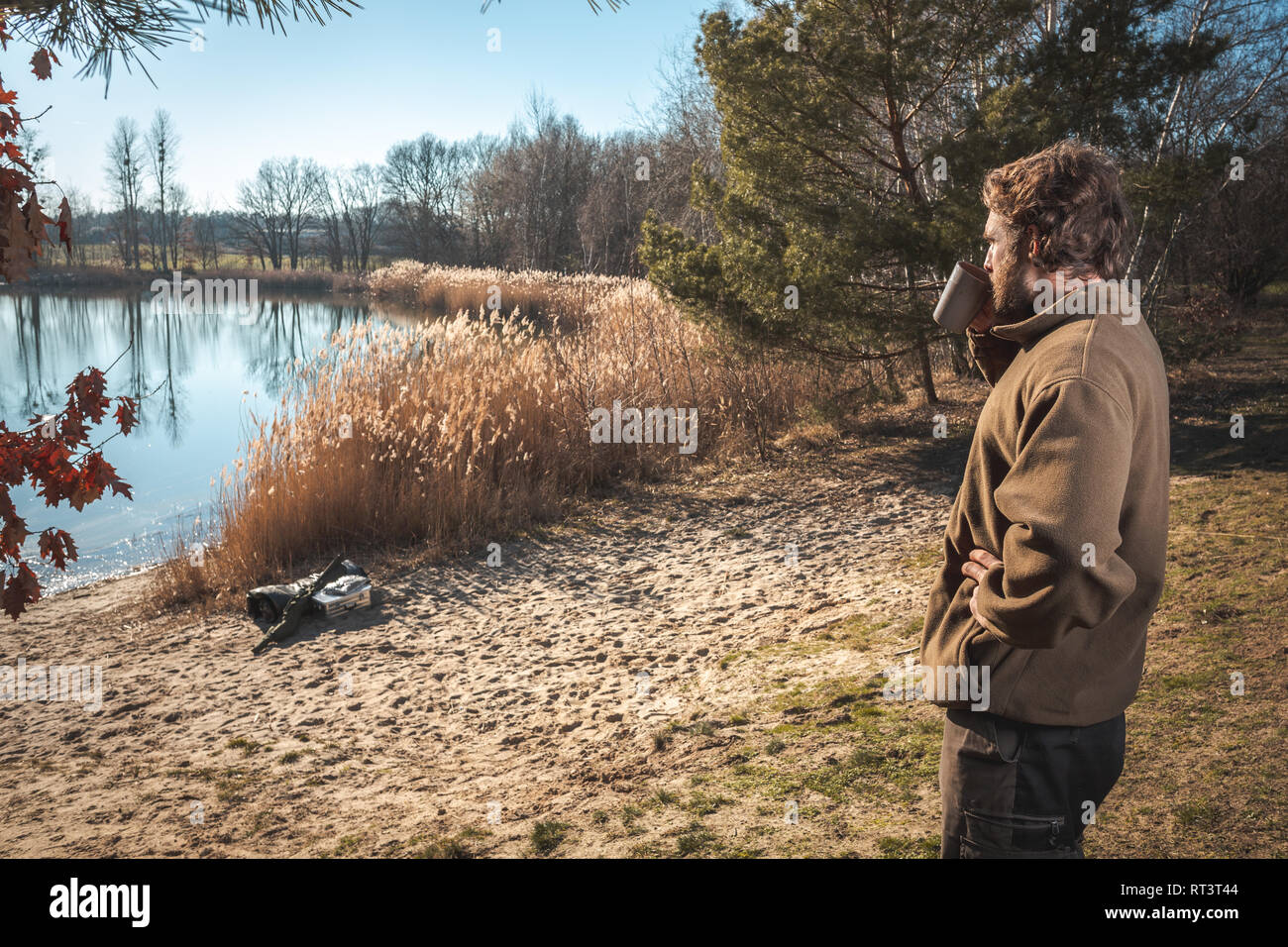 L'homme se détendre avec une tasse de café à un lac Banque D'Images L'homme se détendre avec une tasse de café à un lac Banque D'Images