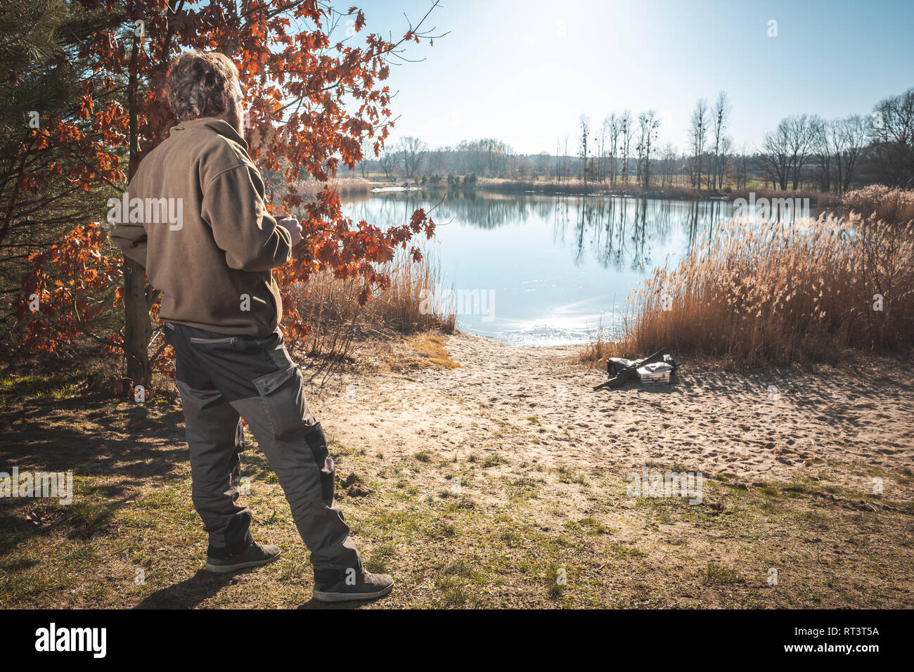 Homme avec une tasse à café avec vue sur un petit lac au soleil Banque D'Images Homme avec une tasse à café avec vue sur un petit lac au soleil Banque D'Images