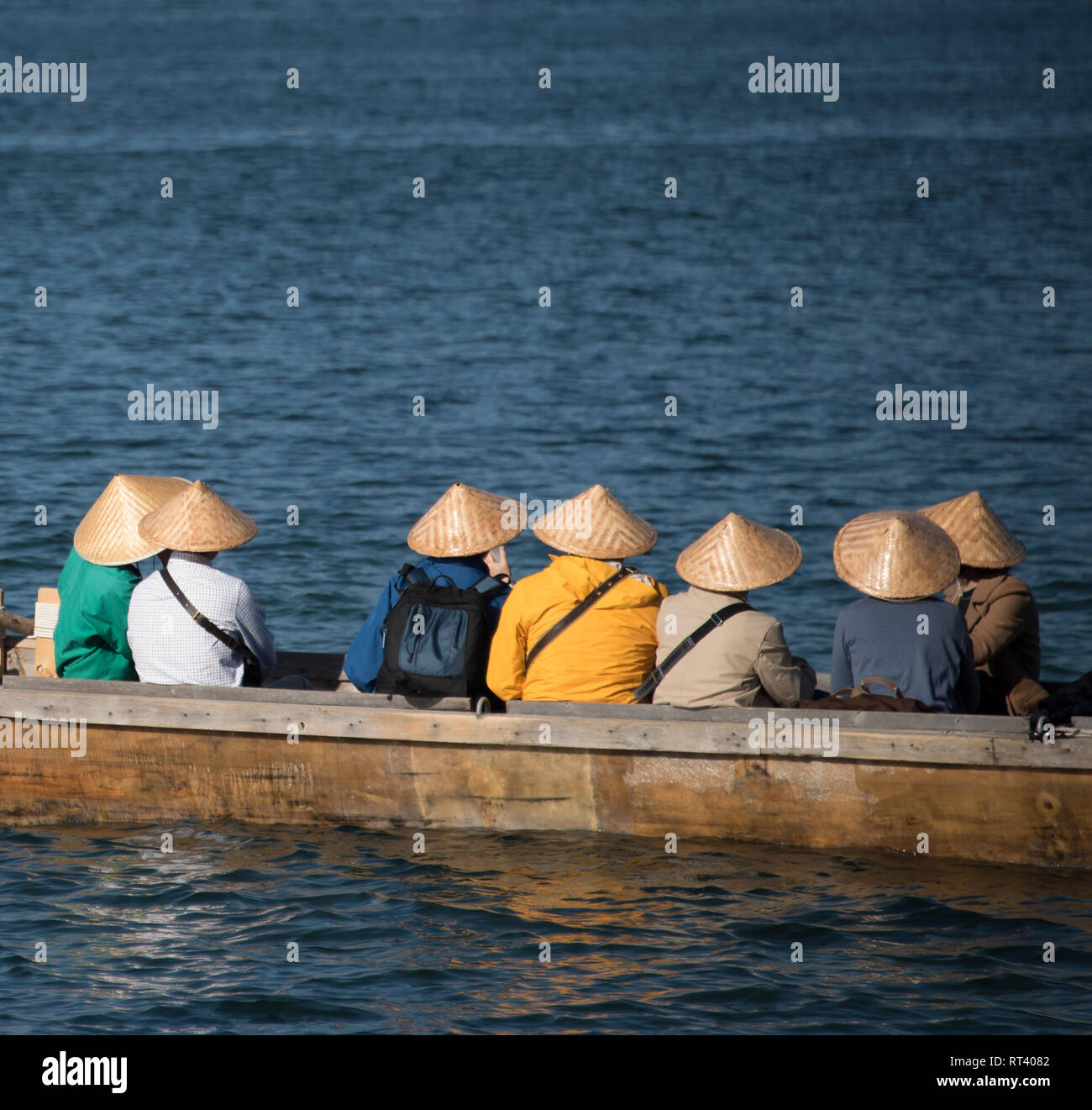 Les touristes portant des chapeaux traditionnels dans un bateau à Miyajima, Japon Banque D'Images