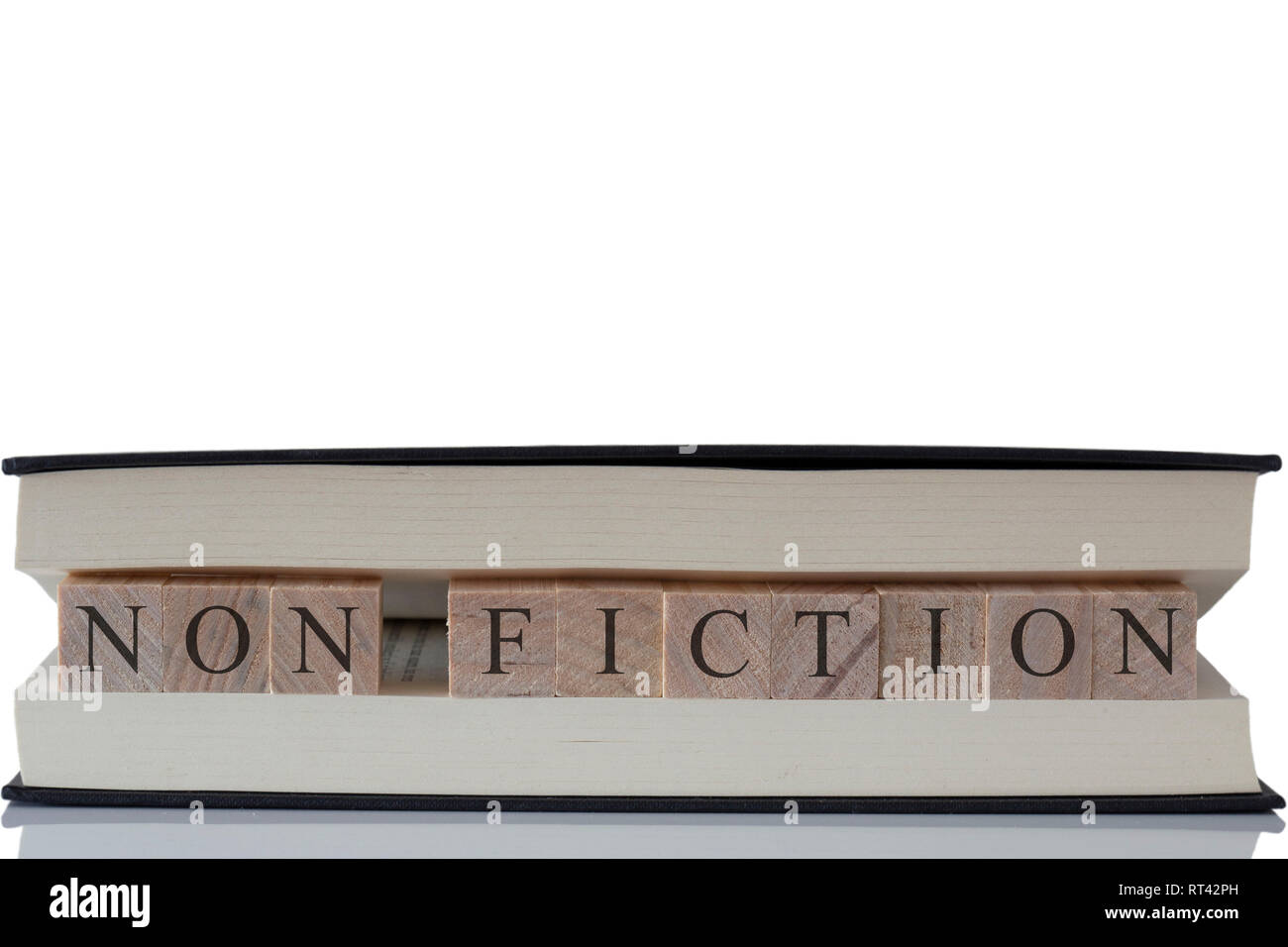 Non fiction écrit sur des blocs de bois à l'intérieur un livre isolé sur fond blanc avec la réflexion Banque D'Images