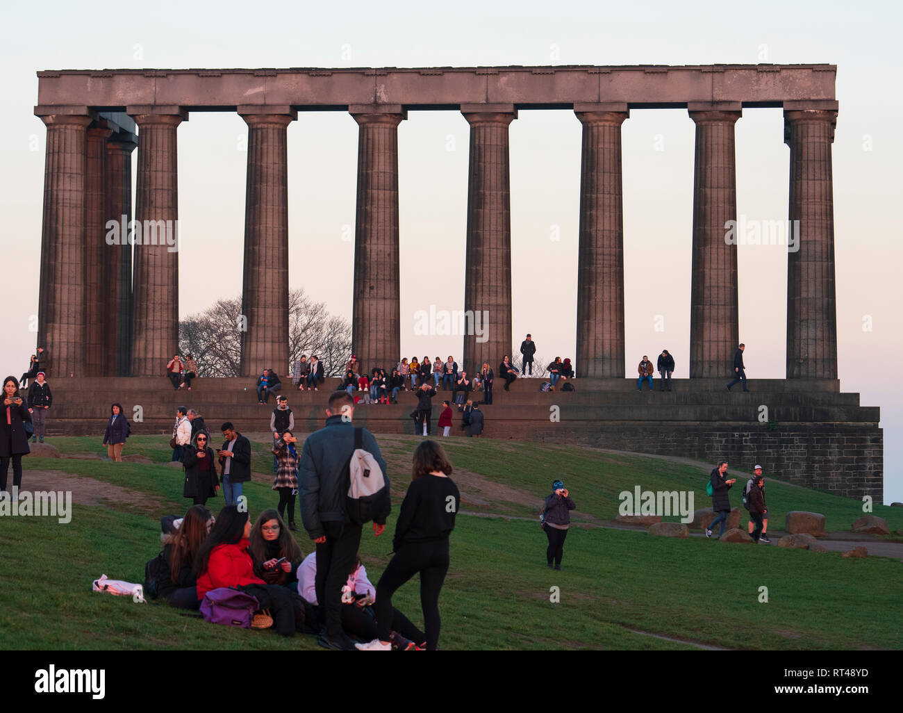 Les touristes se regroupent sur Calton Hill au Monument National à regarder le coucher du soleil, Édimbourg, Écosse, Royaume-Uni Banque D'Images