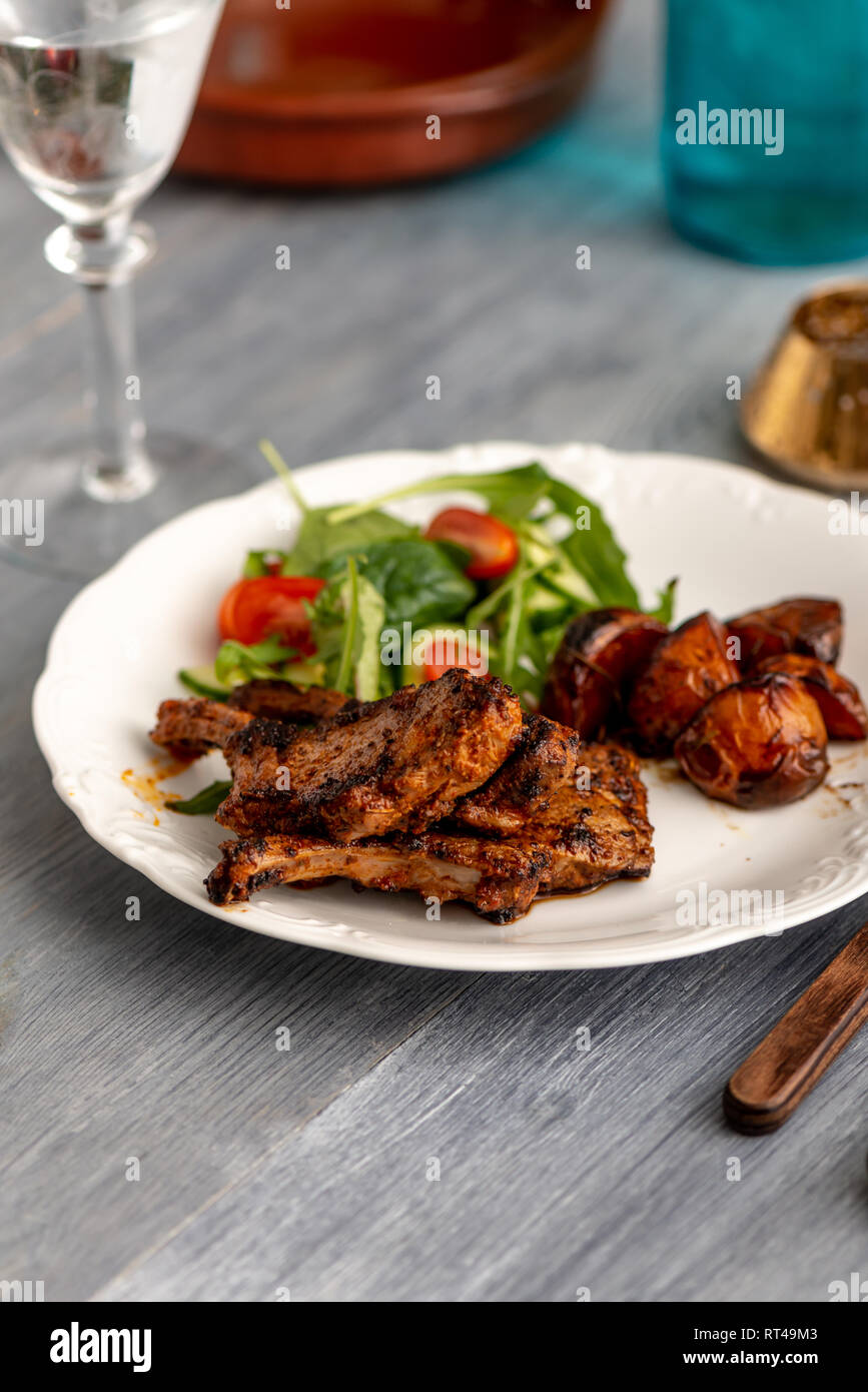 Côtelettes d'agneau sur une assiette de légumes et une portion de pommes de terre ​ Banque D'Images