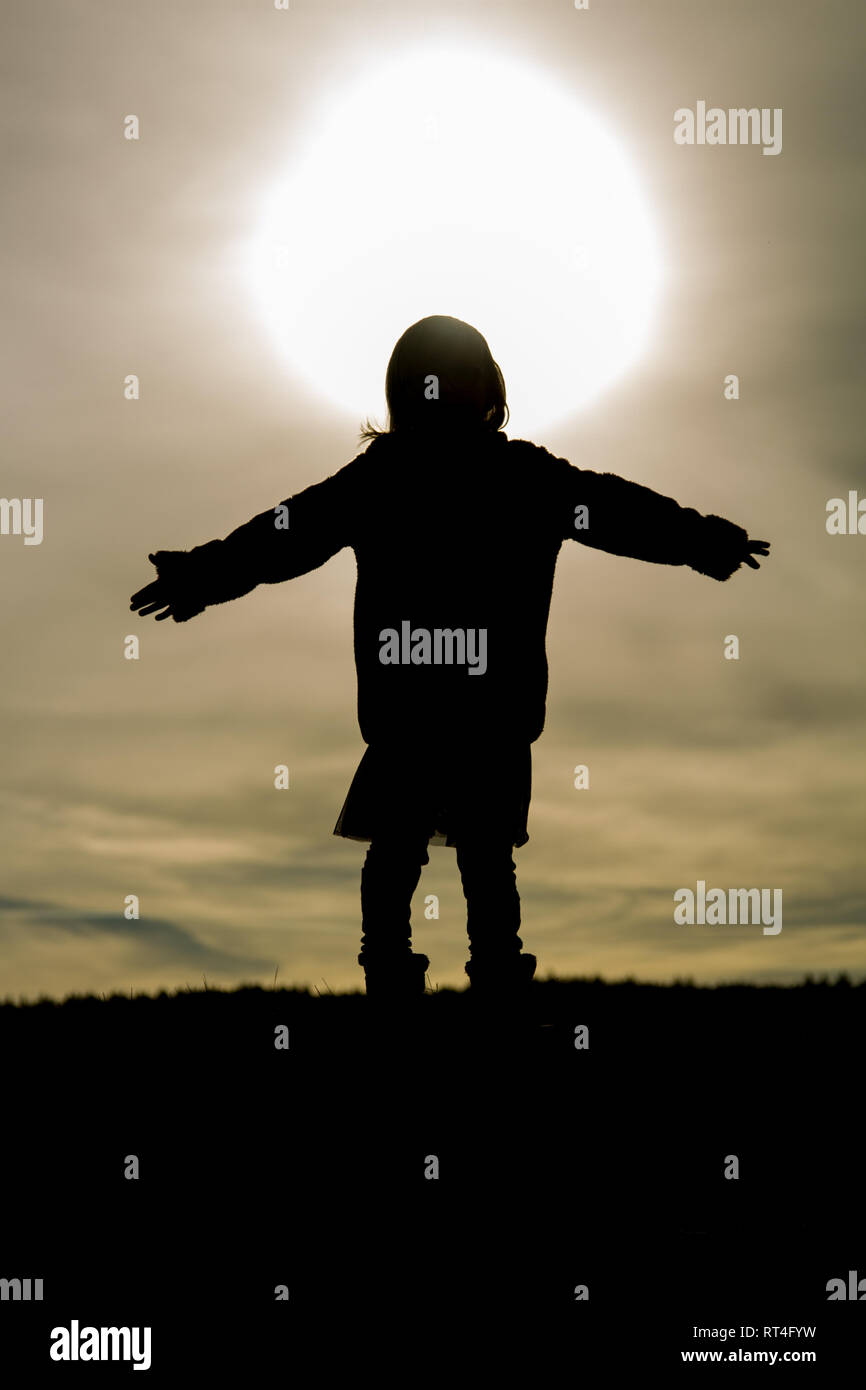 Silhouette d'un enfant contre le soleil Banque D'Images