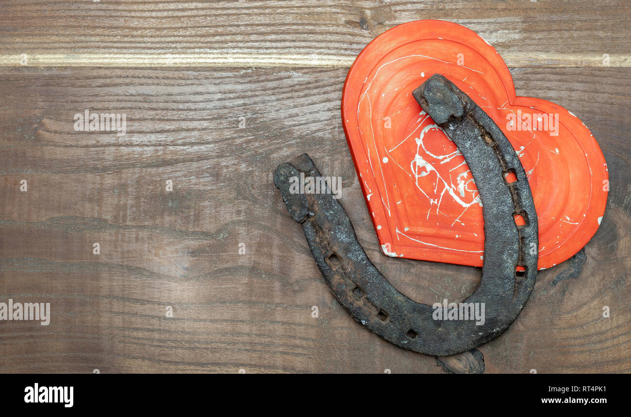 Coeur rouge et en fer à cheval comme un symbole de bonheur et d'amour ensemble sur un fond de bois Banque D'Images