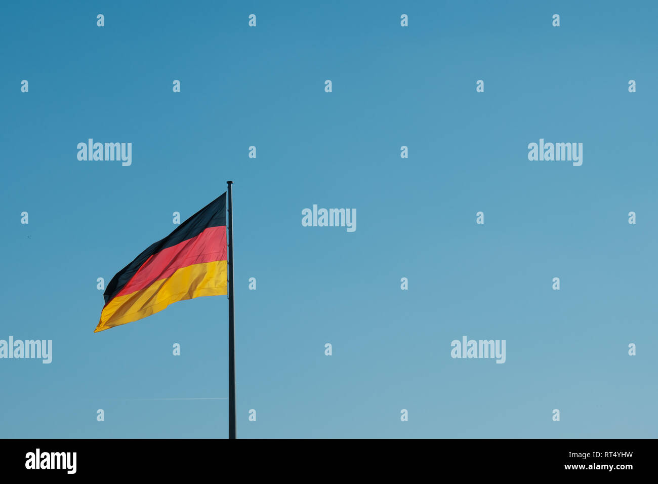 Drapeau allemand sur perche sur fond de ciel bleu avec copie espace - Banque D'Images