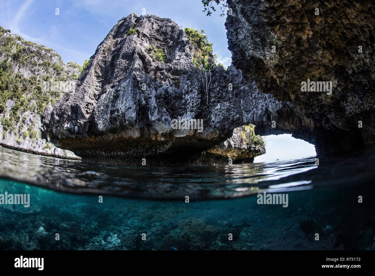 Une arche naturelle a érodé dans un calcaire à distance près de l'île de Misool, Raja Ampat. Banque D'Images Une arche naturelle a érodé dans un calcaire à distance près de l'île de Misool, Raja Ampat. Banque D'Images