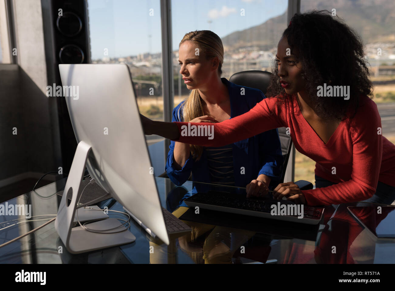 Les femmes cadres travaillant sur pc de bureau at desk in office Banque D'Images