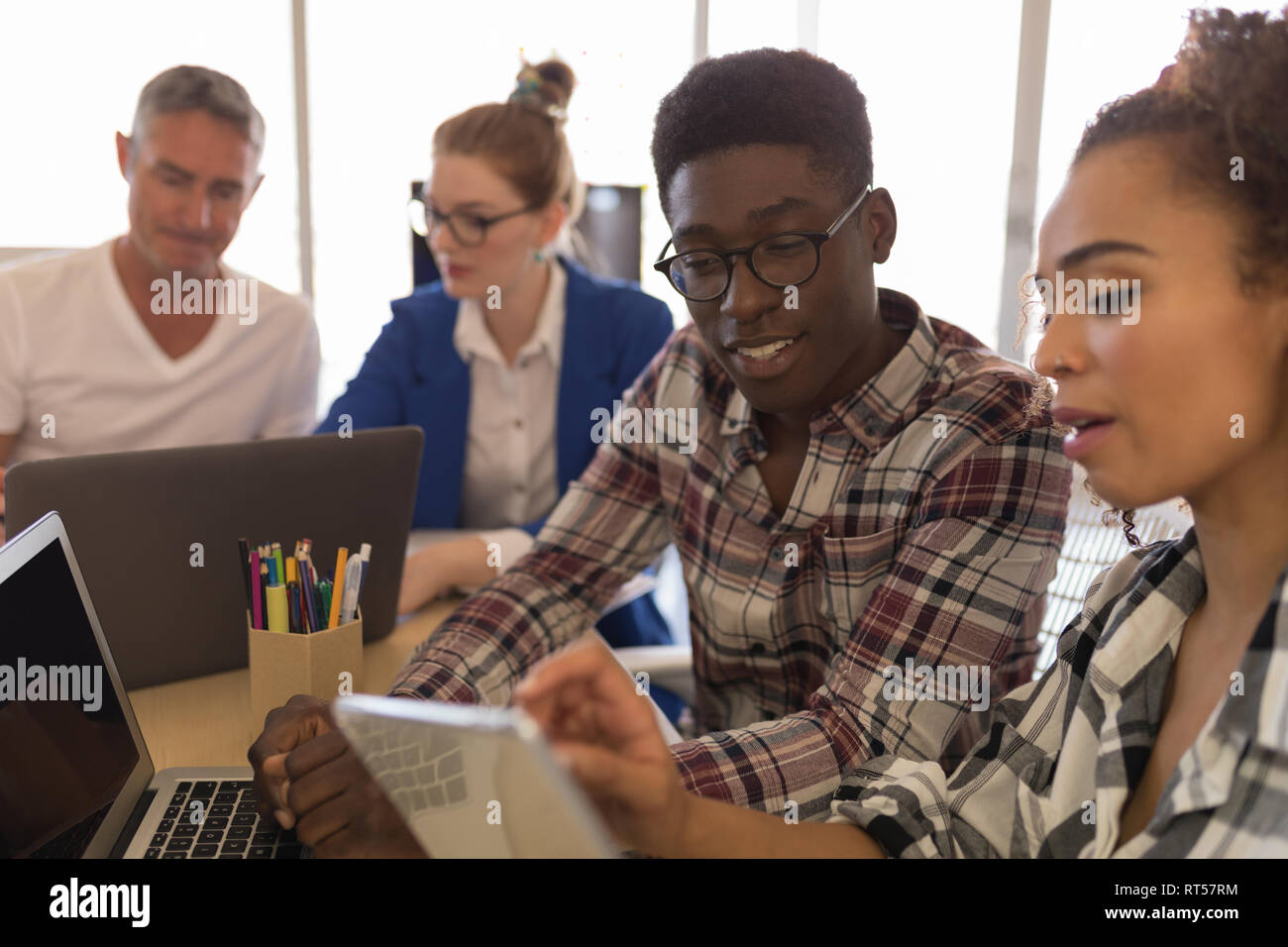 Les cadres masculins et féminins au cours digital tablet in office Banque D'Images