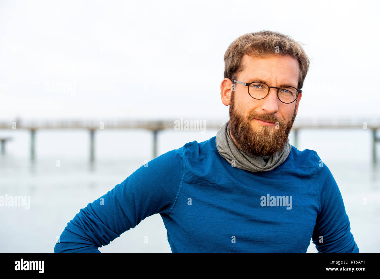 Allemagne, Rerik, portrait d'homme barbu en face de la mer portant des lunettes cerclées de métal Banque D'Images