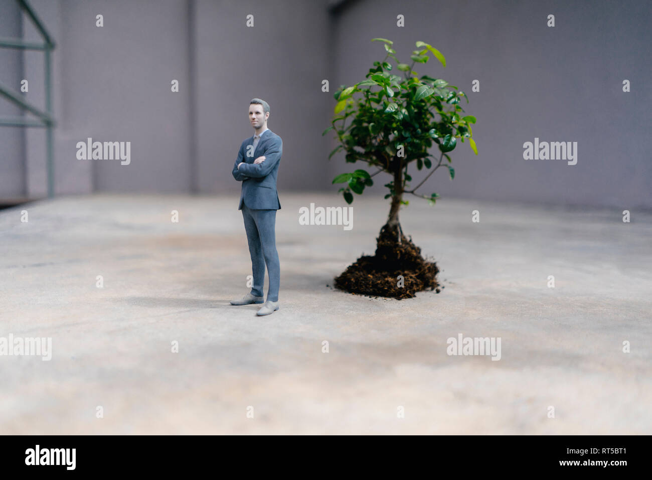 Figurine homme debout à côté d'un petit arbre Banque D'Images