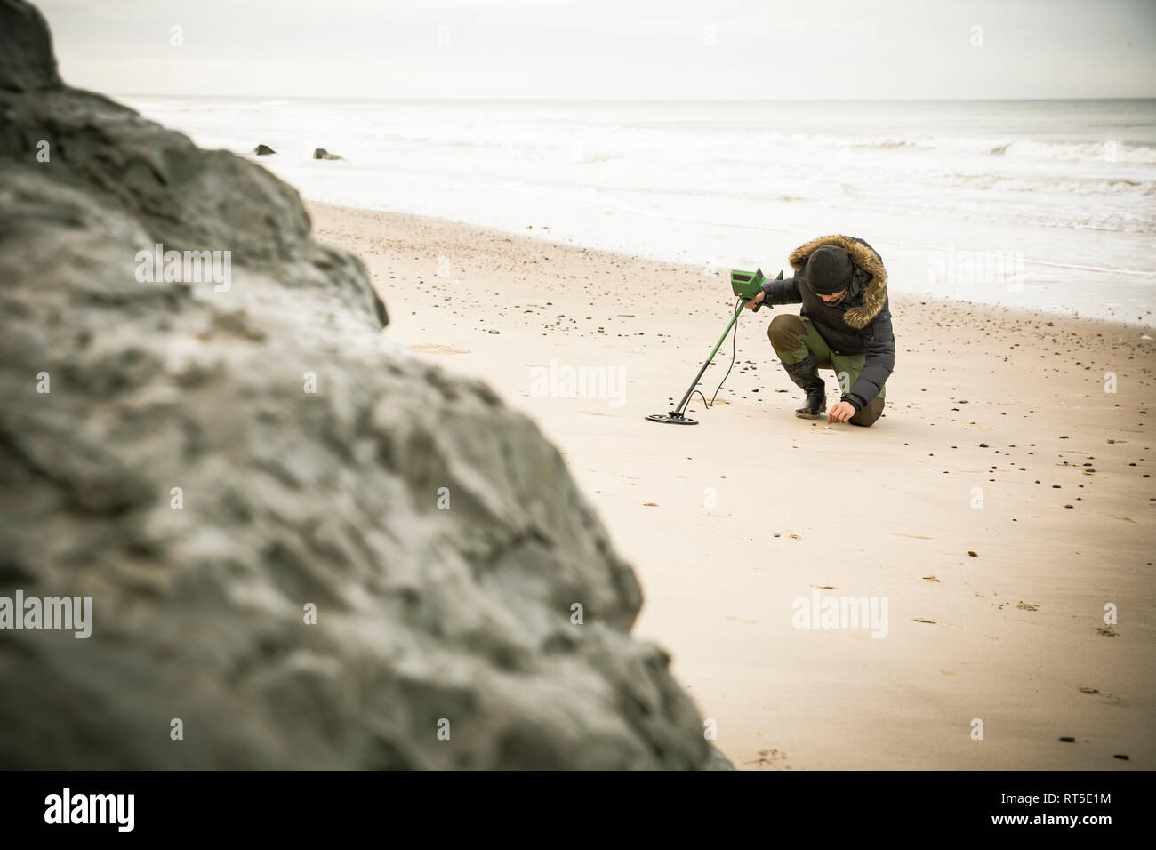 Homme avec détecteur de métal à la plage de sable Banque D'Images