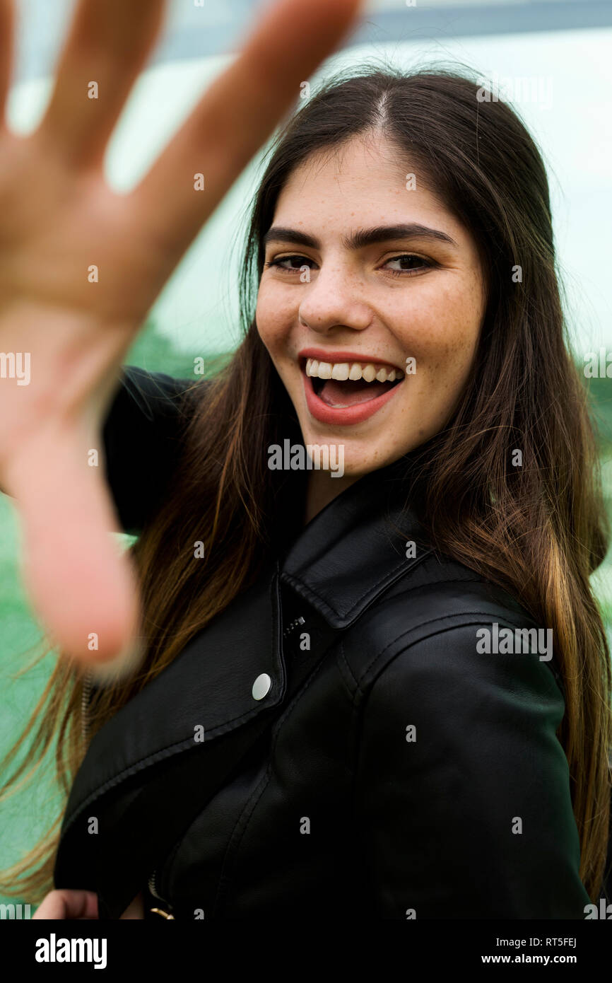 Portrait de jeune femme aux longs cheveux bruns à la collecte sa main Banque D'Images