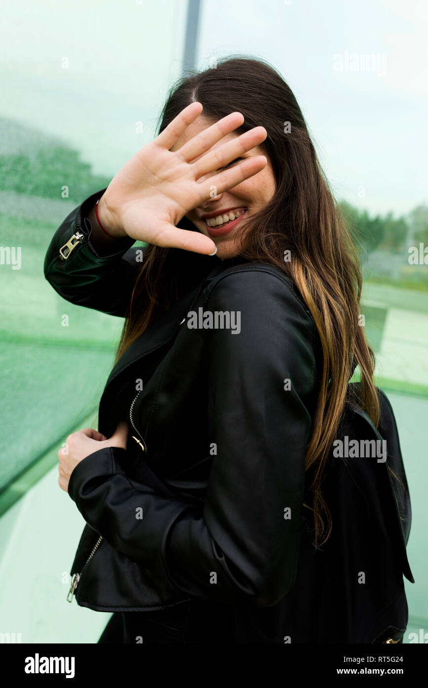 Happy young woman couvrant son visage avec sa main Banque D'Images