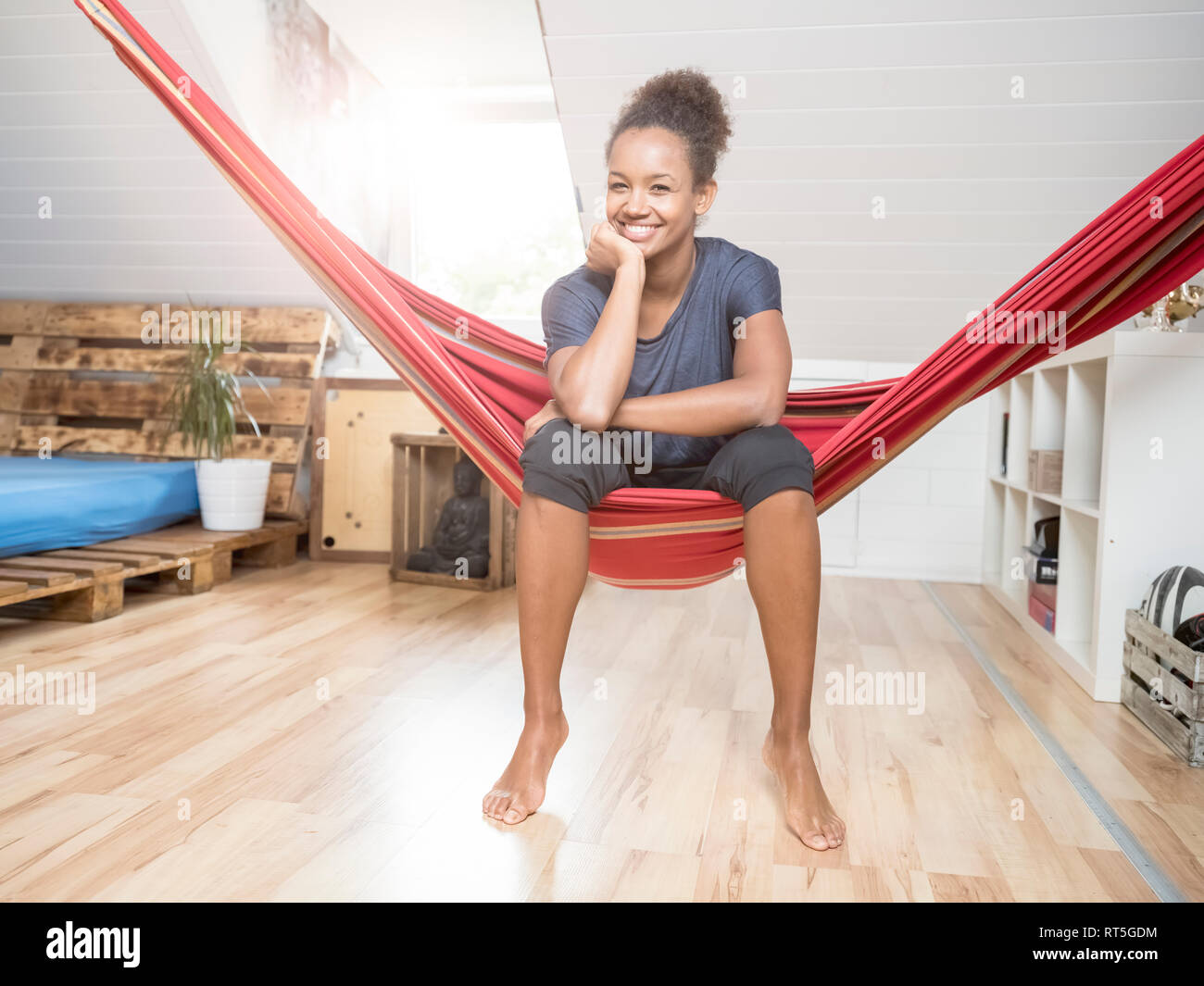 Portrait of happy young woman sitting in hammock Banque D'Images