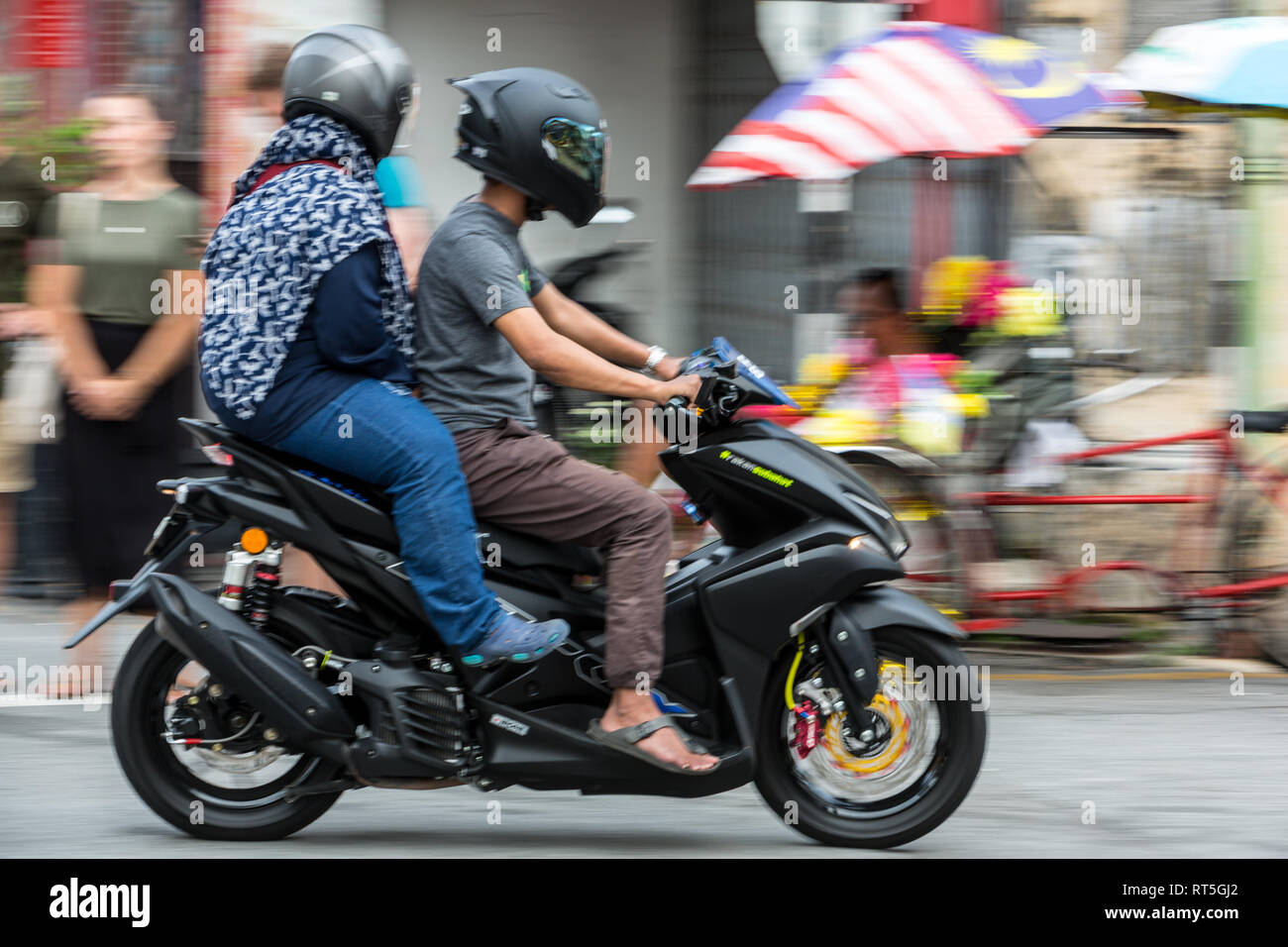 George Town, Penang, Malaisie. Couple de Malaisie sur moto. Banque D'Images