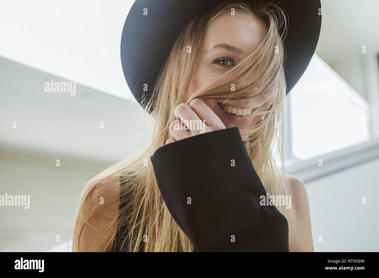 Portrait of laughing blond woman wearing black hat Banque D'Images