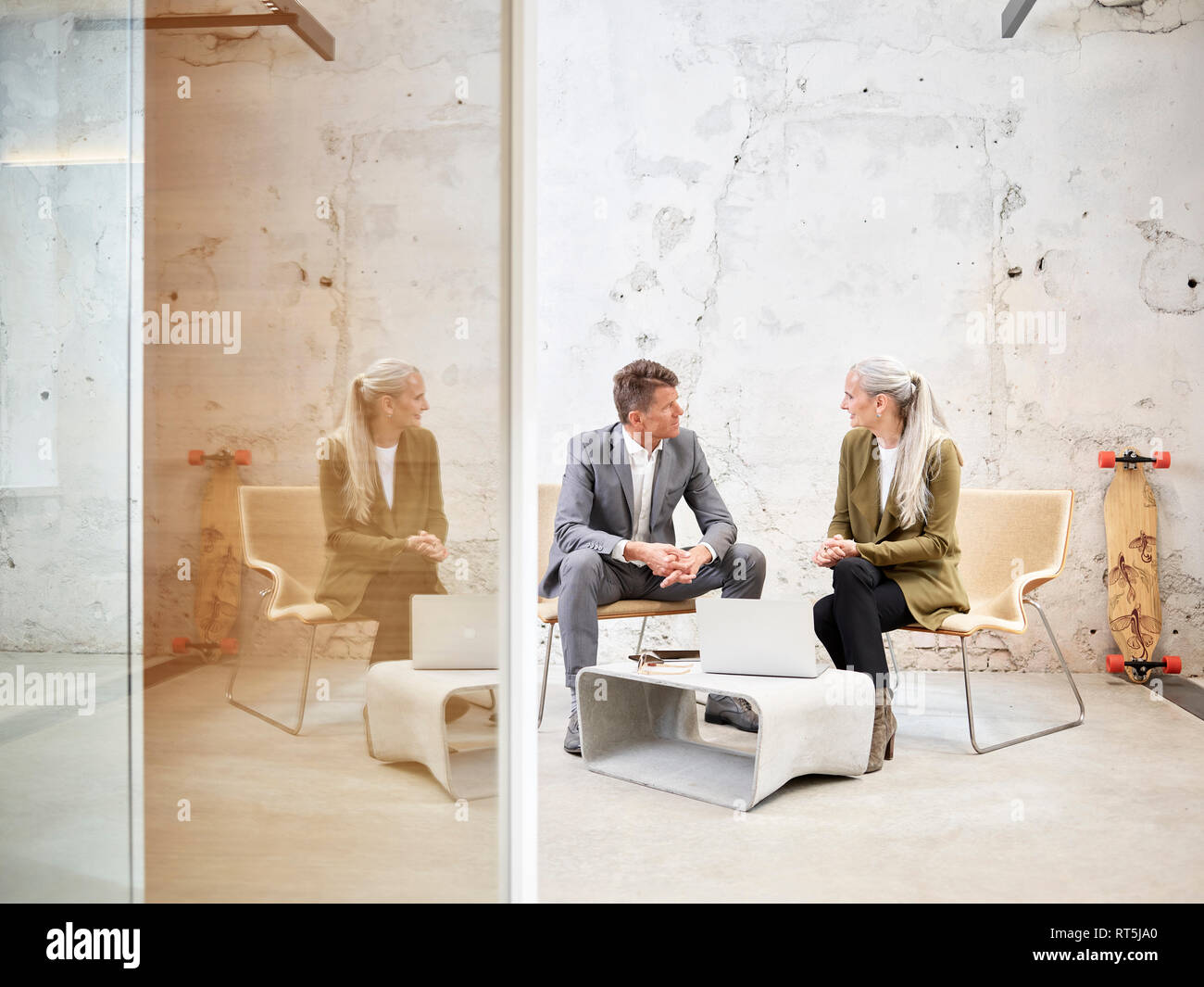 Businessman and businesswoman talking in modern office Banque D'Images