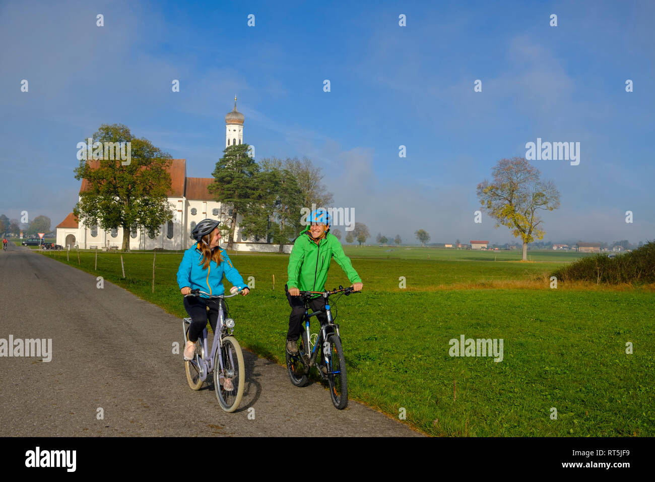 L'Allemagne, l'église de pèlerinage Saint Coloman et couple de cyclistes en tournée Banque D'Images