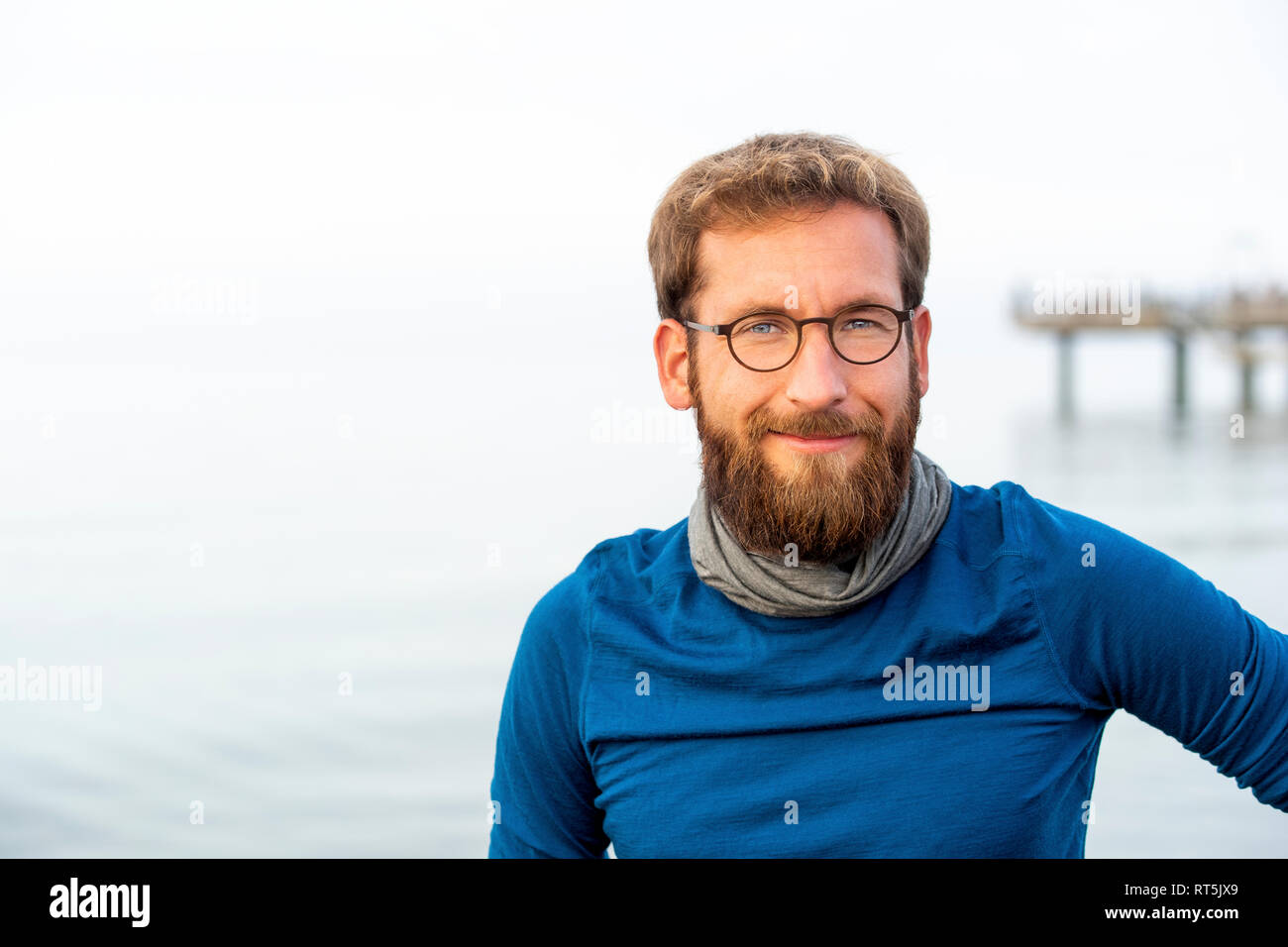 Allemagne, Rerik, portrait d'homme barbu en face de la mer portant des lunettes cerclées de métal Banque D'Images