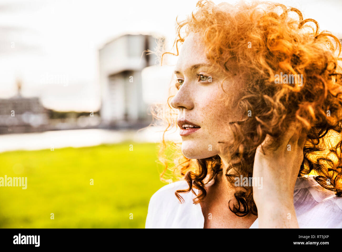 Allemagne, Cologne, portrait de jeune femme de rousseur avec curly red hair Banque D'Images