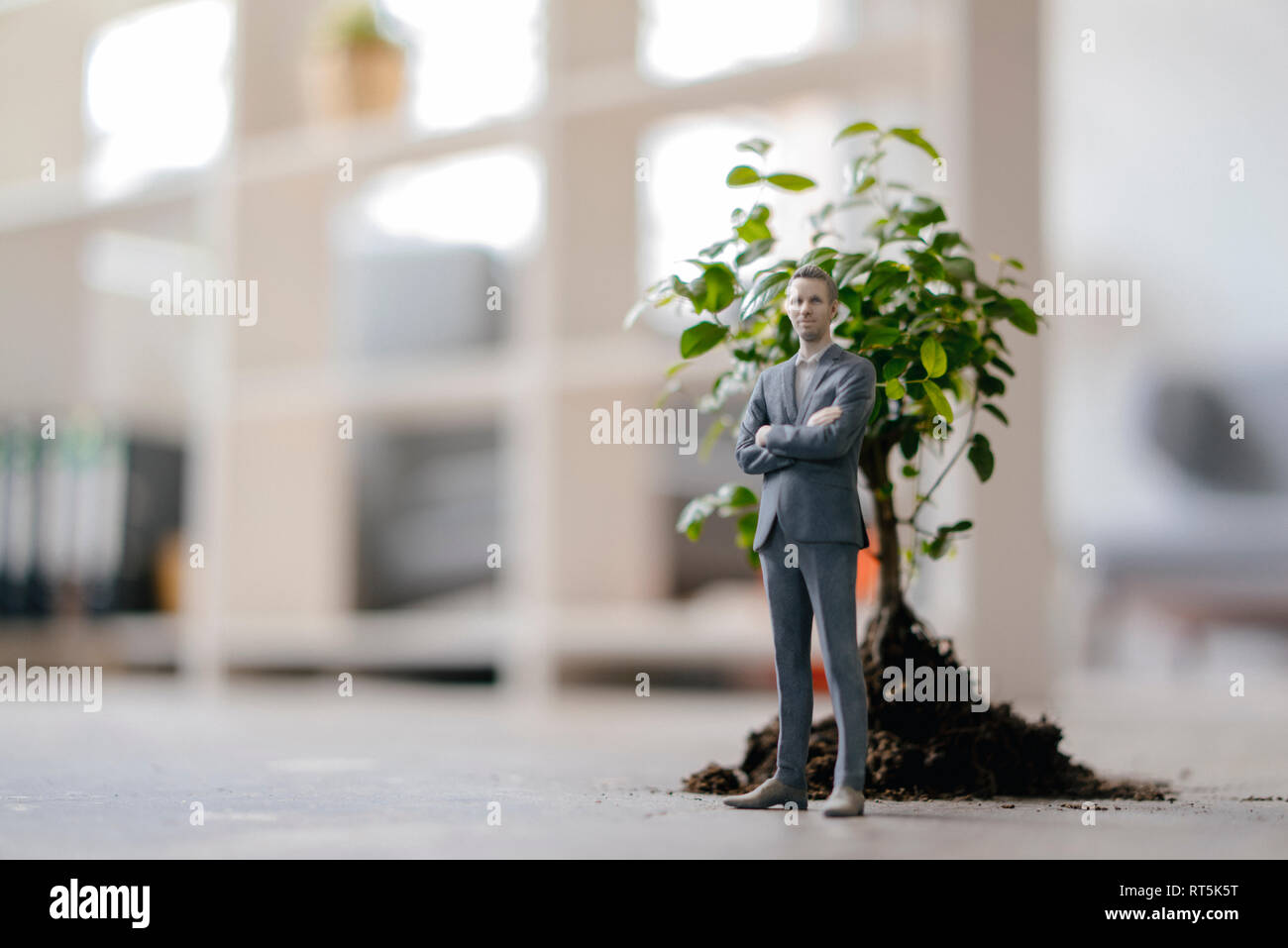 Figurine homme debout à côté d'un petit arbre Banque D'Images