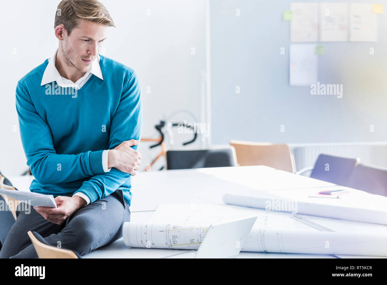 Businessman looking at blueprints in office Banque D'Images