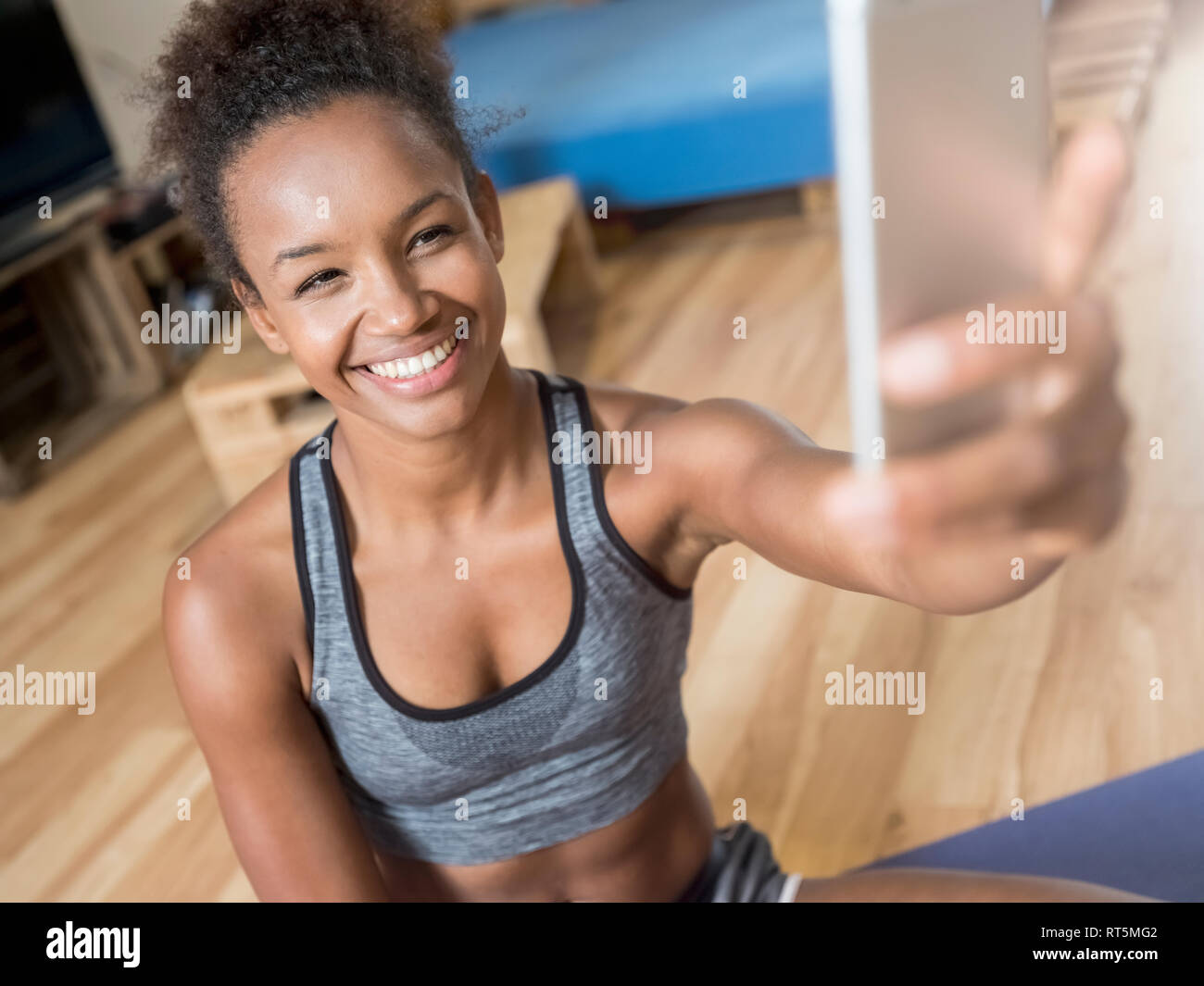 Smiling young woman in sportswear en tenant un selfies Banque D'Images